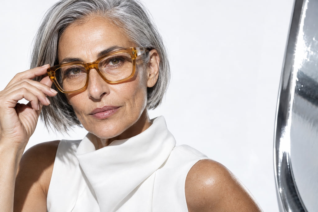 Silver-haired woman wearing translucent amber glasses